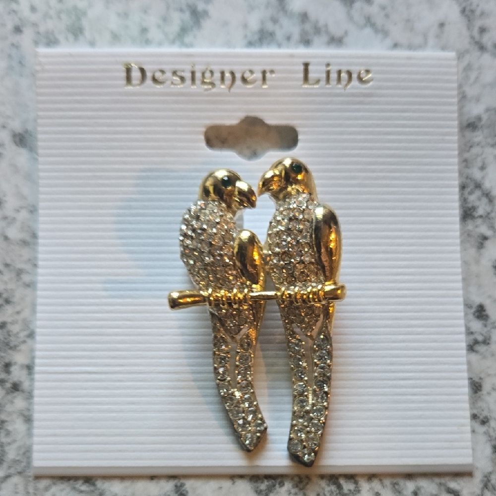 Vintage gold parrot brooch with rhinestone accents on body in emerald eyes